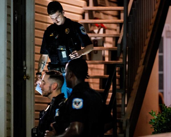 A Cobb County police officer exits the scene of a triple shooting off Riverside Parkway.