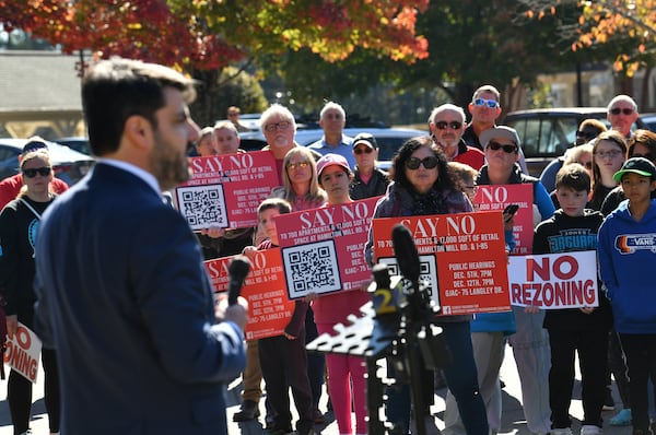 House Majority Leader Chuck Efstration (foreground) speaks as a group of residents, who oppose a proposed development in the area, hold signs at Hamilton Mill Community, Friday, November 3, 2023, in Dacula. (Hyosub Shin / Hyosub.Shin@ajc.com)