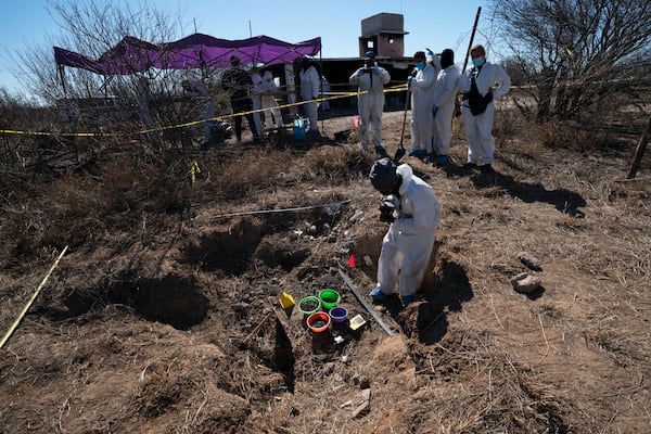 FILE - Forensic technicians excavate a field on a plot of land referred to as a cartel "extermination site" where burned human remains are buried, on the outskirts of Nuevo Laredo, Mexico, Feb. 8, 2022. (AP Photo/Marco Ugarte, File)