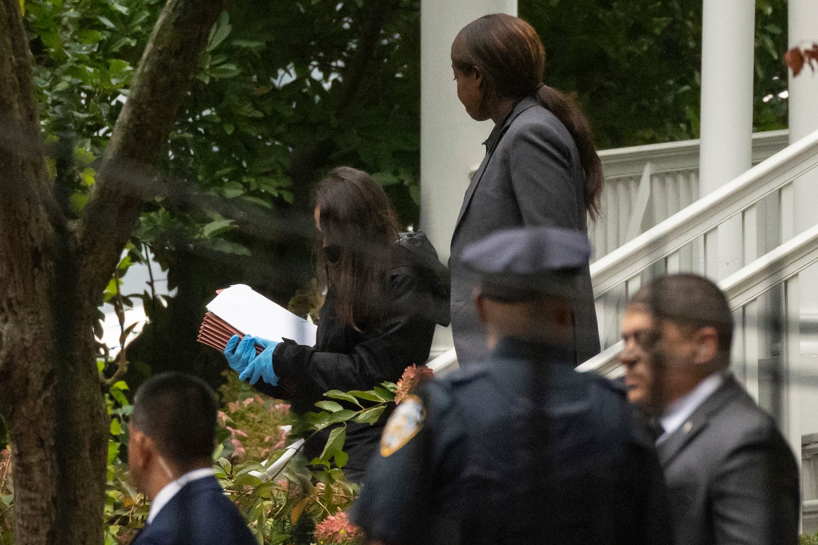 A person wearing gloves and carrying Manila folders exits Gracie Mansion, the official residence of New York City Mayor Eric Adams, Thursday, Sept. 26, 2024, in New York. (AP Photo/Yuki Iwamura)