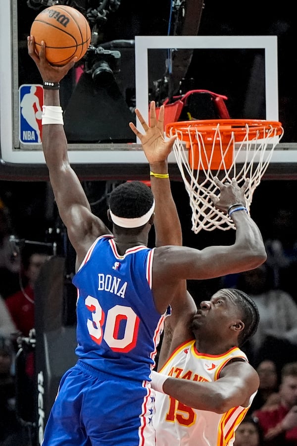 Philadelphia 76ers center Adem Bona (30) shoots againmst Atlanta Hawks center Clint Capela (15) during the first half of an NBA basketball game, Monday, March 10, 2025, in Atlanta. (AP Photo/Mike Stewart)