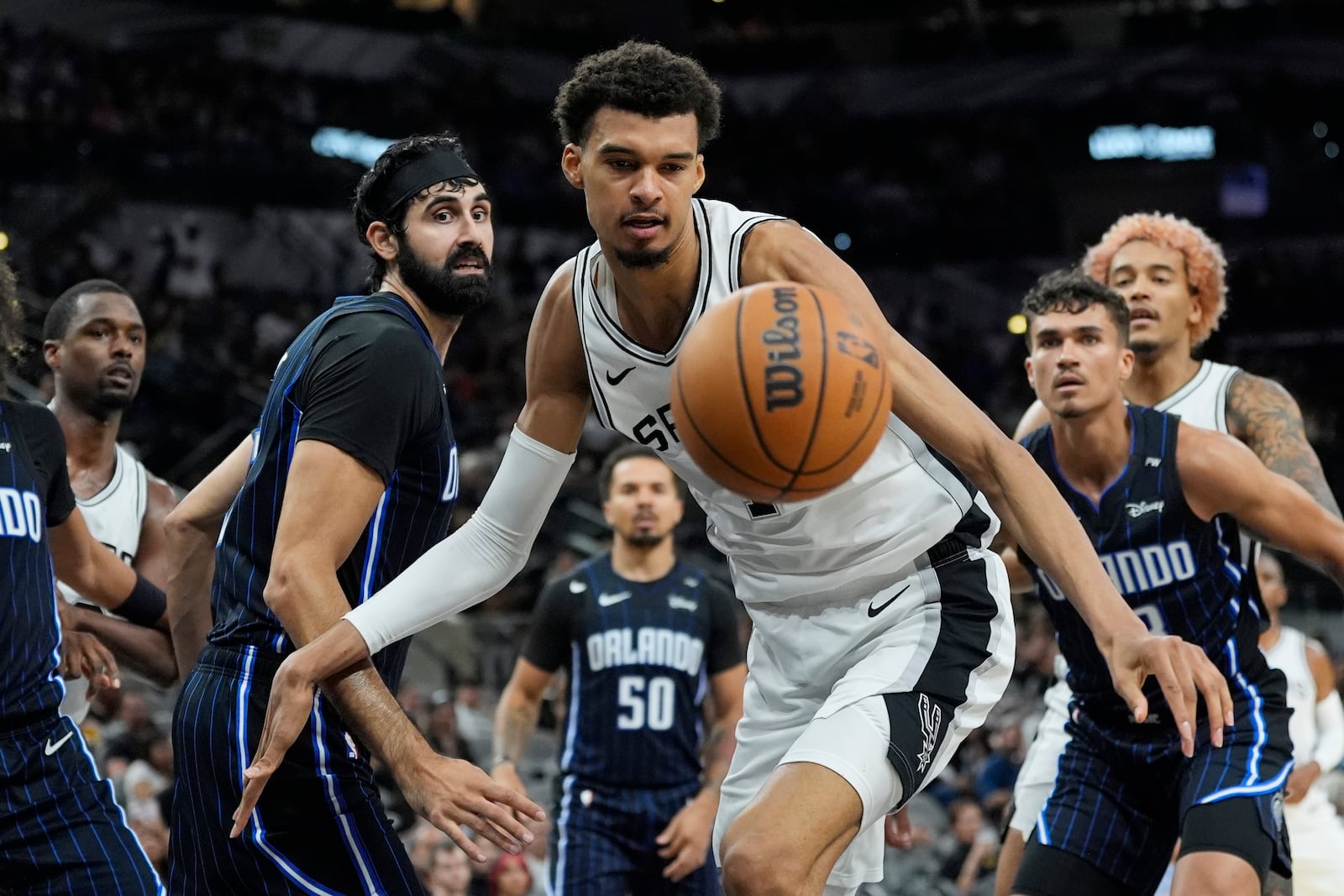 San Antonio Spurs center Victor Wembanyama (1) chases a loose ball after he was blocked during the second half of a preseason NBA basketball game against the Orlando Magic in San Antonio, Wednesday, Oct. 9, 2024. (AP Photo/Eric Gay)