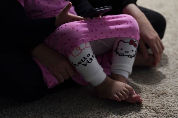 Rahmani's young daughter and wife sit together in their apartment in Laurel, Md., Monday, March 3, 2025. The family moved to the U.S. in November with the federal refugee program, a vetted form of legal migration to the U.S. for those fleeing persecution. (AP Photo/Jessie Wardarski)