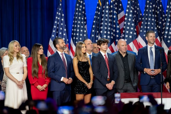 From left, Susie Wiles, Tiffany Trump, Tony Fabrizio, Kimberly Guilfoyle, Donald Trump Jr., Walt Nauta (hidden two people), Kai Madison Trump, Dan Scavino, Corey Lewandowski, Donald Trump III, Dana White, Chris LaCivita and Eric Trump, listen as Republican presidential nominee former President Donald Trump speaks at an election night watch party Wednesday, Nov. 6, 2024, in West Palm Beach, Fla. (AP Photo/Alex Brandon)