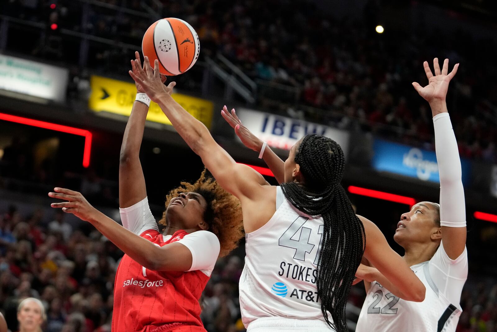 Indiana Fever's NaLyssa Smith (1) shoots over Las Vegas Aces' Kiah Stokes and A'ja Wilson (22) during the first half of a WNBA basketball game, Wednesday, Sept. 11, 2024, in Indianapolis. (AP Photo/Darron Cummings)