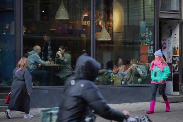 People walk along a shopping street in the center of Helsinki, Finland, Saturday, March 15, 2025. (AP Photo/Sergei Grits)