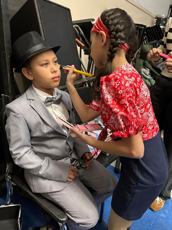 Tristan Oles, 12, left, gets makeup done by castmate Ava Maskouri, 10, right, on opening night of the Theatre Palisades Youth production of Crazy for You after the group lost its theater in the Palisades fire, Los Angeles, California, Feb. 28, 2025. (AP Photo/Jocelyn Gecker)