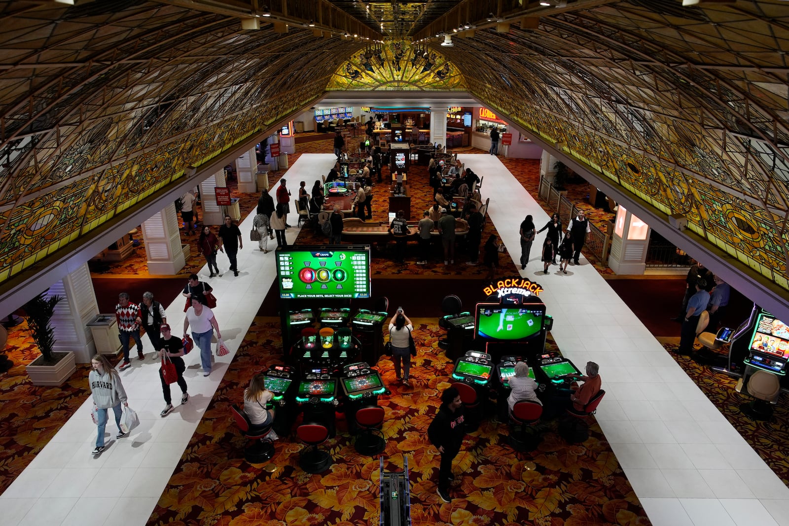 FILE - People walk through the casino floor at the Tropicana hotel-casino Friday, March 29, 2024, in Las Vegas. (AP Photo/John Locher, File)