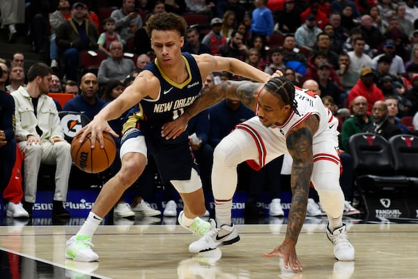 New Orleans Pelicans' Dyson Daniels (11) battles Chicago Bulls' DeMar DeRozen (11) for a loose ball during the second half of an NBA basketball game Saturday, Dec. 2, 2023, in Chicago. Chicago won 124-118. (AP Photo/Paul Beaty)