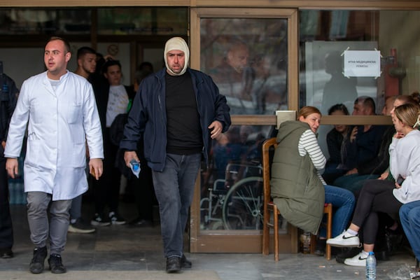 An injured man exits a hospital in the town of Kocani, North Macedonia, Sunday, March 16, 2025, following a massive fire in a nightclub early Sunday. (AP Photo/Visar Kryeziu)