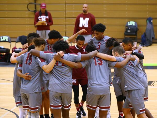 Morehouse College coach Emory Lightfoot Jr. and assistant coach Naterria Mitchell look on as their team huddles up taking the court to play Life University in a volleyball match Feb. 16 in Marietta. (Curtis Compton / Curtis.Compton@ajc.com)