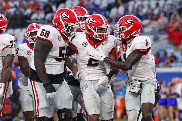 Georgia running back Kendall Milton (2) celebrates his one-yard touchdown run with offensive lineman Micah Morris (56) and wide receiver Marcus Rosemy-Jacksaint (1) during the fourth quarter against Florida at EverBank Stadium, Saturday, October 27, 2023, in Jacksonville, Fl. Georgia won 43-20 against Florida. (Jason Getz / Jason.Getz@ajc.com)