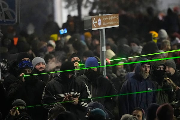 Demonstrators use lasers against the police during a rally outside the parliament building to protests against the government's decision to suspend negotiations on joining the European Union in Tbilisi, Georgia, early Thursday, Dec. 5, 2024. (AP Photo/Pavel Bednyakov)