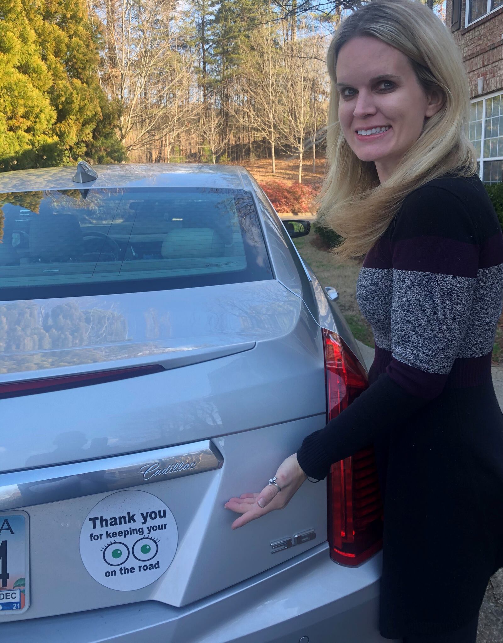 Molly Welch shows off one of her stickers on a friend's car. (Courtesy of Molly Welch)