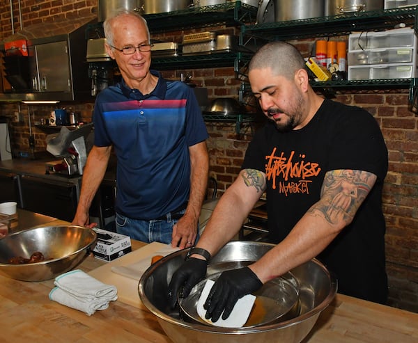 Retiree Mike Smith (left) gets a brief lesson from Jake Pollitz of Staplehouse. Chris Hunt for The Atlanta Journal-Constitution 