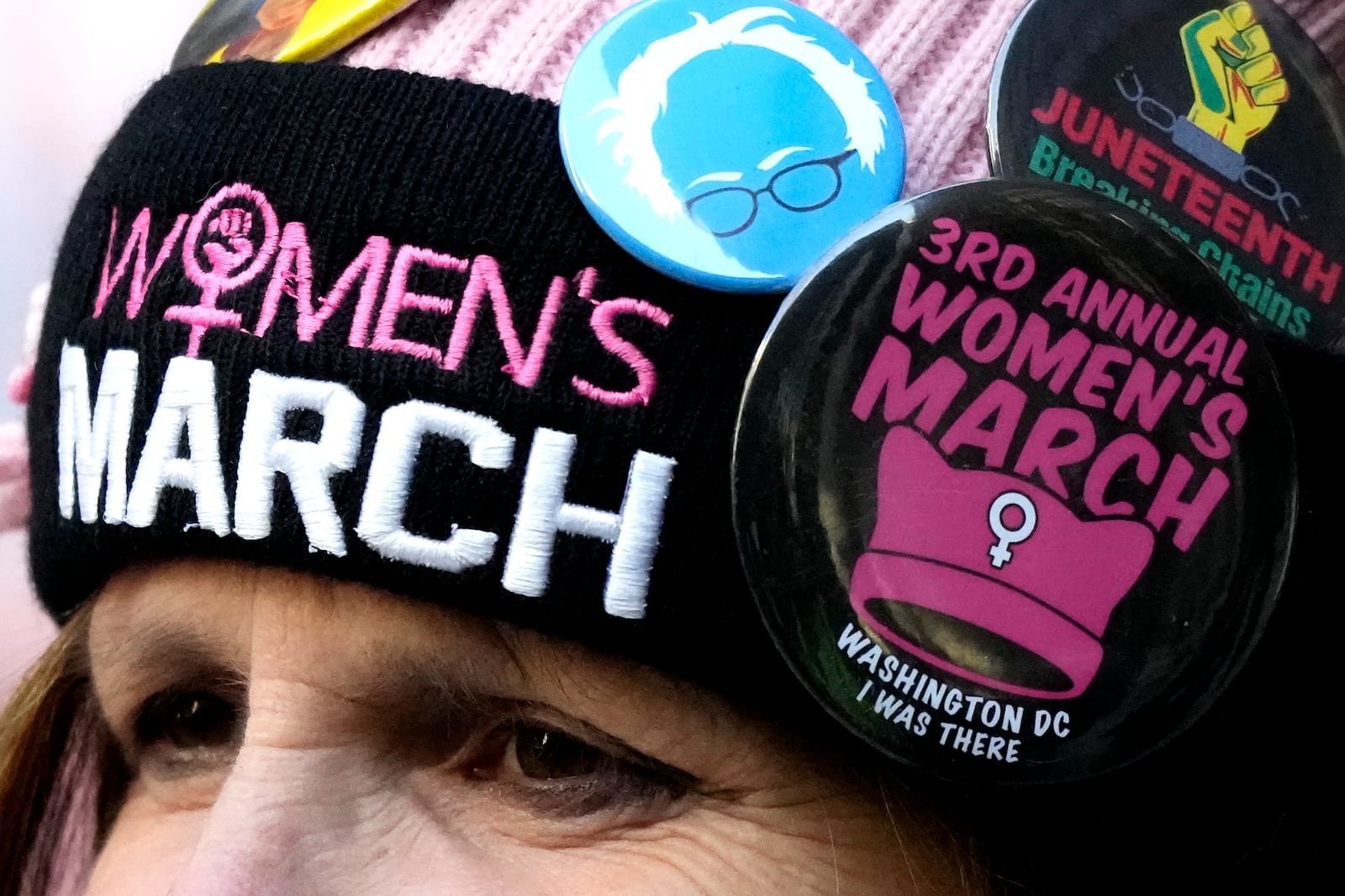 A woman wears pins as she attends the National Women's March in Chicago, Saturday, Nov. 2, 2024. (AP Photo/Nam Y. Huh)