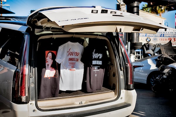 Tee shirts are displayed hanging in the back of a Cadillac Escalade during a merchandise Pop-Up event for the movie Anora on Saturday, Nov. 9, 2024 in Los Angeles. (AP Photo/Richard Vogel)