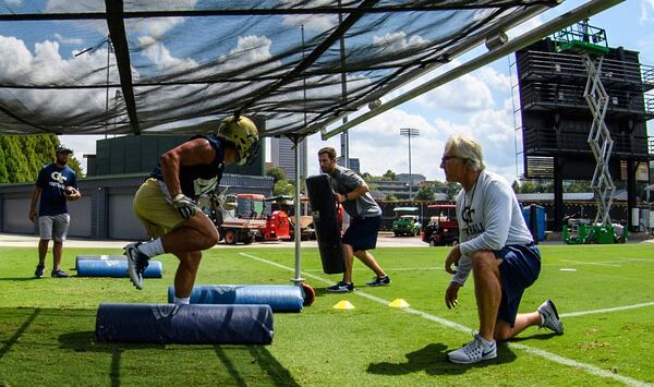 Georgia Tech defensive coordinator Ted Roof watches linebacker T.D. Roof (his son) go through footwork drills at practice.