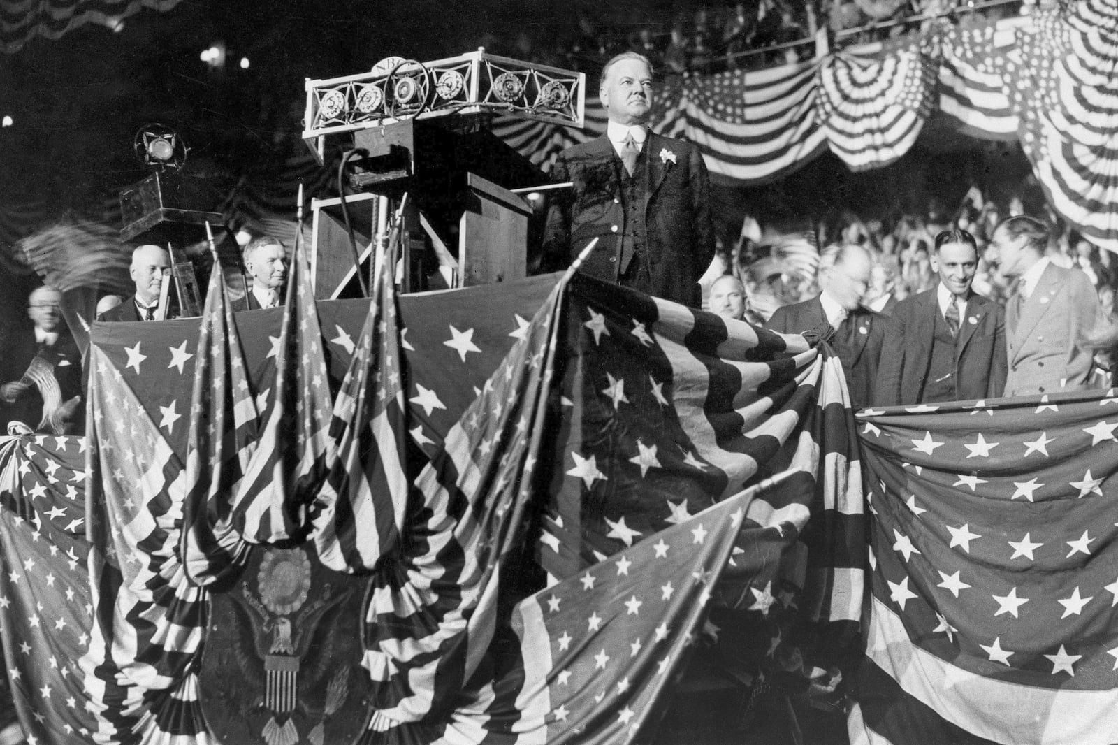 FILE - In this Oct. 22, 1928 file photo, Republican presidential candidate Herbert Hoover delivers an address from a U.S. flag-draped podium at Madison Square Garden in New York. (AP Photo/File)