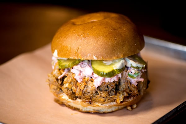 Whole Hog sandwich with pickles, slaw, crunchy bits, pasilla and gaujillo sauce, and spicy sauce. Photo credit- Mia Yakel.