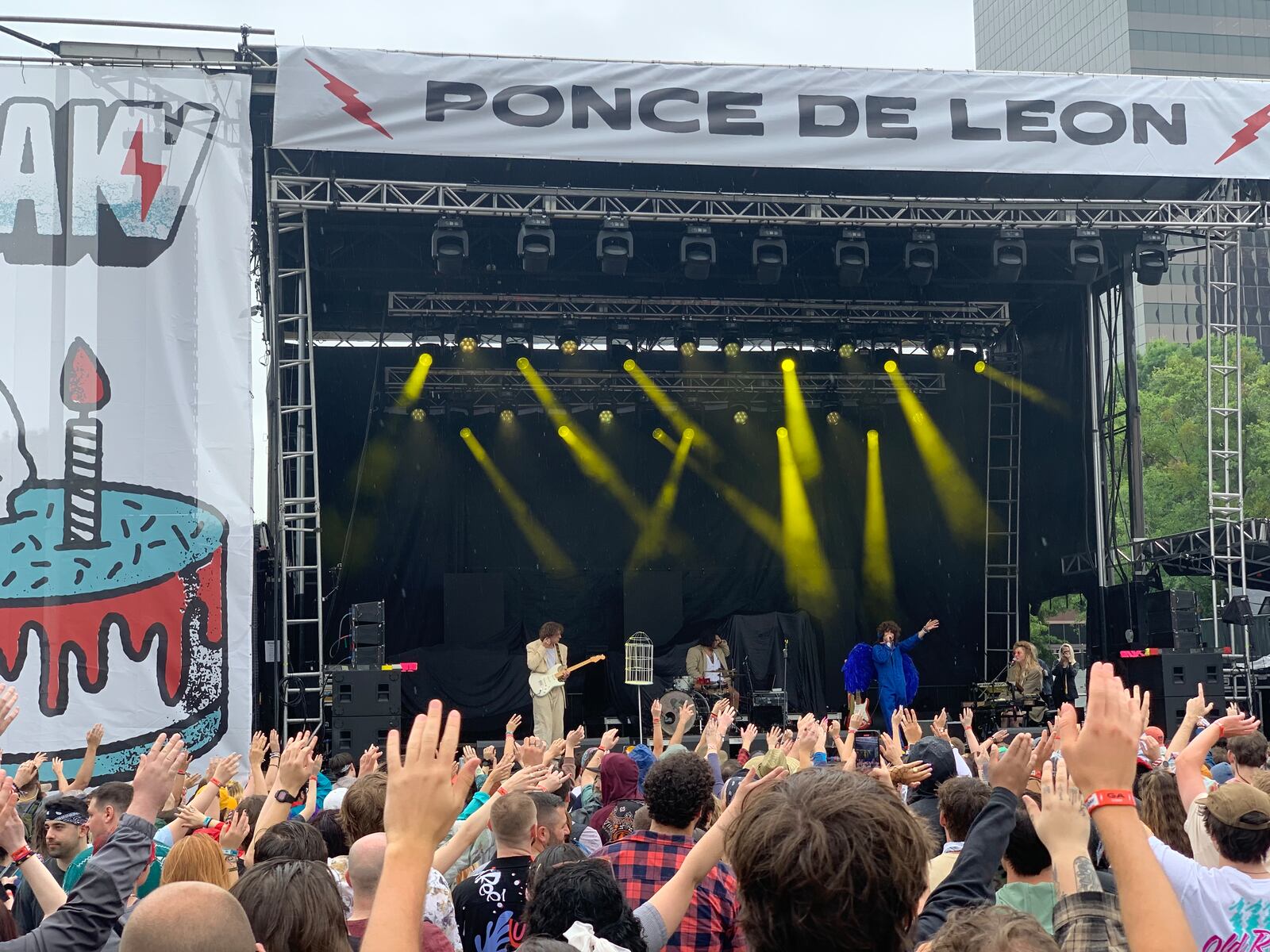 Fans wave their hands along with the music as indie-pop band Arlie plays under light rain at Shaky Knees music festival on Friday, May 5, 2023. (Taylor Croft/taylor.croft@ajc.com)