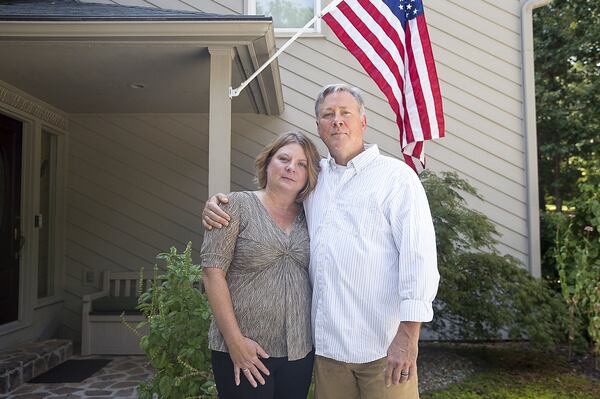 Former DeKalb County police officer Robert “Chip” Olsen and his wife Kathy Olsen stand for a photo at their Alpharetta residence on September 13, 2019. The couple has been married for 16 years. (Alyssa Pointer/alyssa.pointer@ajc.com)