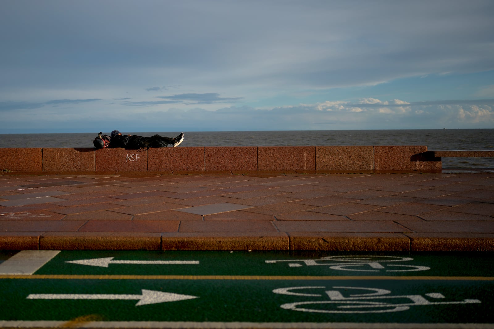 A man rests the wall of a promenade ahead of Sunday's general election, in Montevideo, Uruguay, Friday, Oct. 25, 2024. (AP Photo/Natacha Pisarenko)