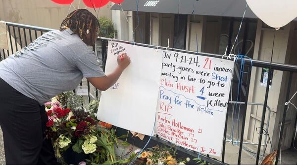 FILE - Nichole Smith signs a memorial sign Sept. 23, 2024, remembering the four people who were killed in a shooting outside a nightclub in Birmingham, Ala. (AP Photo/Safiyah Riddle, File)