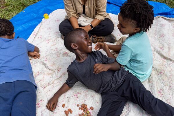 Arian Tiamiyu, 4, a student at Gather Forest School, smiles with his classmate at a park in Atlanta on Thursday, June 30, 2022. (Arvin Temkar / arvin.temkar@ajc.com)