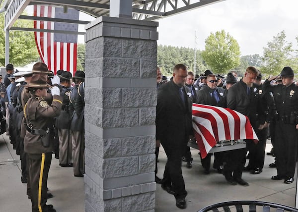 July 11, 2019, Gainesville — Honor Guard members from police departments throughout Georgia salute as the casket containing Hall County sheriff’s Deputy Nicolas Blane Dixon is carried into the Free Chapel Worship Center in Gainesville for the funeral. Dixon is the fourth Georgia law enforcement officer killed in the line of duty this year. Bob Andres / bandres@ajc.com