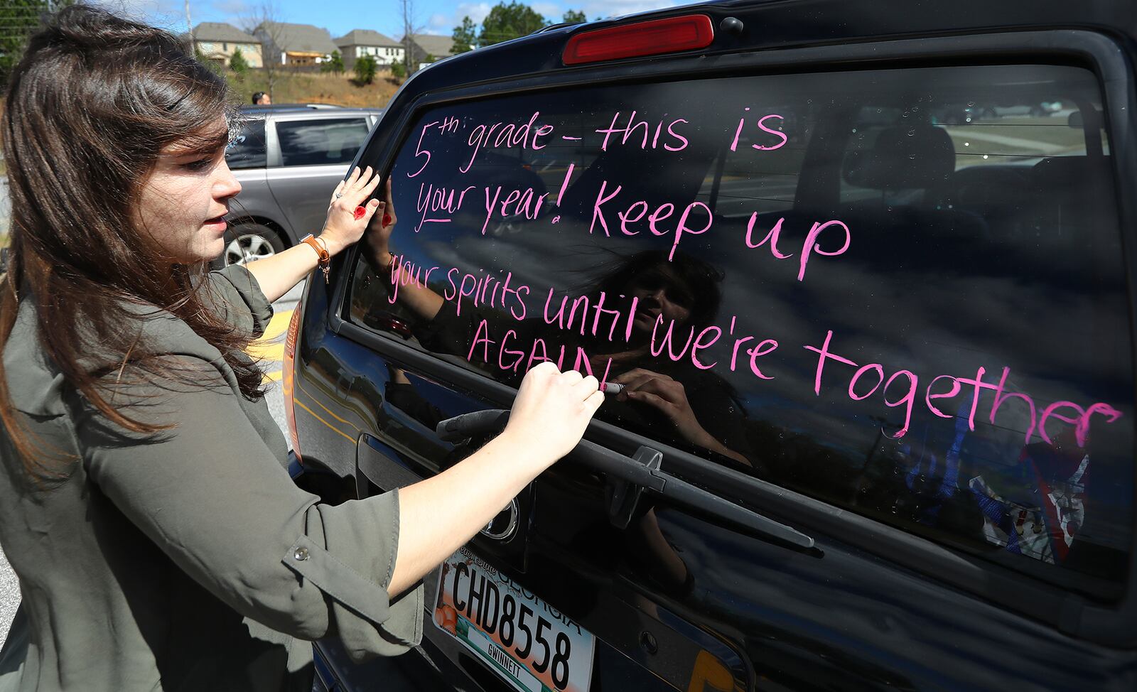 March 25, 2020 Suwanee: Fifth grade teacher Kirsten Zingleman decorates her vehicle as teachers from Roberts Elementary prepare to hold an inspirational school parade driving through area neighborhoods for some face-to-face contact while still maintaining social distance to ease the separation anxiety of their students during the coronavirus on Wednesday, March 25, 2020, in Suwanee. Although distance learning is allowing kids to connect with teachers and get lessons done, the personal touch is missing.       Curtis Compton ccompton@ajc.com