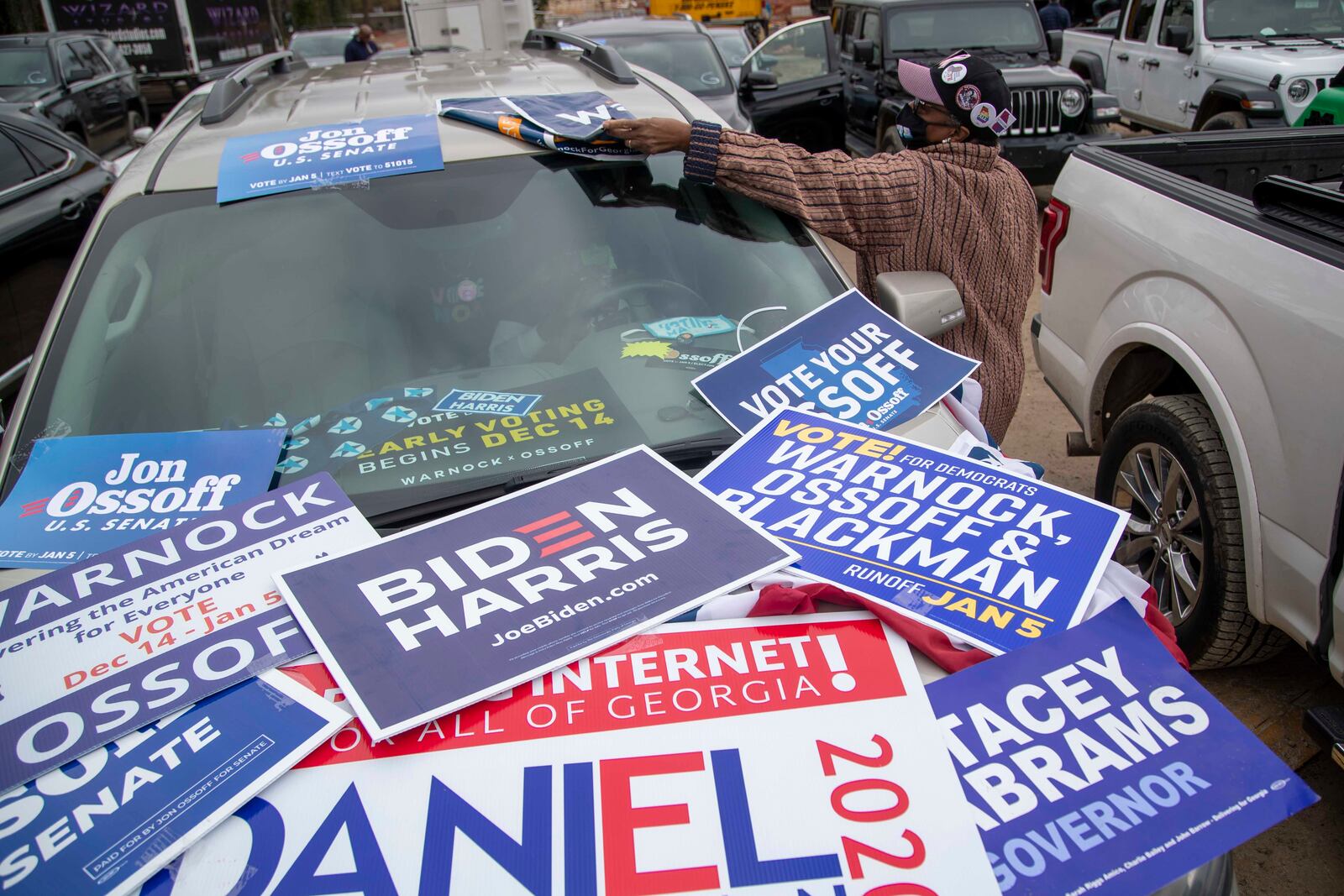 Betty Reece of Augusta adjusts a campaign sign on her vehicle during a “Get Ready to Vote” rally with President-elect Joe Biden, Georgia Democrat leaders and candidates at Pratt-Pullman Yard in Atlanta’s Kirkwood neighborhood, Tuesday, Dec. 15, 2020. (Alyssa Pointer / Alyssa.Pointer@ajc.com)