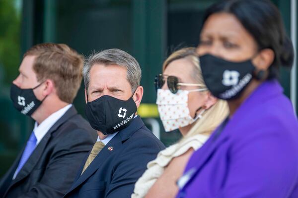 Gov. Brian Kemp wears a mask Thursday as he waits to speak during a ribbon-cutting ceremony for the new Wellstar Kennestone Hospital Emergency Department building in Marietta. The governor encourages Georgians to wear masks as a way to combat the spread of the coronavirus, but he says making it a requirement would be "a bridge too far." (ALYSSA POINTER / ALYSSA.POINTER@AJC.COM)