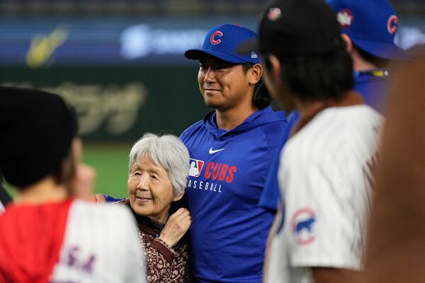 Chicago Cubs starting pitcher Shota Imanaga, center right, poses for photos with fans after the team's MLB Japan Series baseball game against the Los Angeles Dodgers in Tokyo, Japan, Tuesday, March 18, 2025. (AP Photo/Hiro Komae)