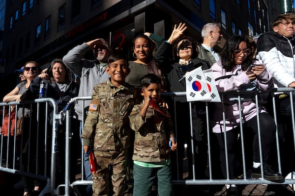 Dereck Rodriguez 10, and his brother, Thiago Rodriguez, 6, wait for their father Mauro Rodriguez, who is in the Army, to march past during the annual Veterans Day Parade, Monday, Nov. 11, 2024, in New York. (AP Photo/Adam Gray)