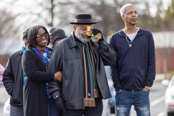 Stacy Redmond's brother, Courtney, wipes his eyes during a speech.