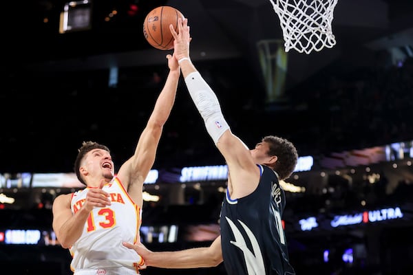 Milwaukee Bucks center Brook Lopez, right, blocks Atlanta Hawks guard Bogdan Bogdanovic (13) during the first half of a semifinal game in the NBA Cup basketball tournament Saturday, Dec. 14, 2024, in Las Vegas. (AP Photo/Ian Maule)