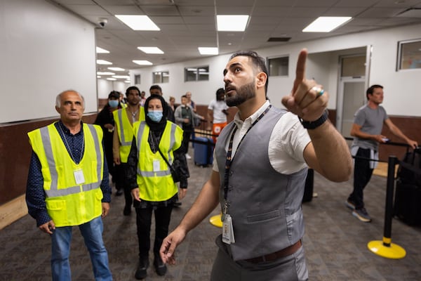 Mirwais Jalali, a recruiter for aviation contractor Unifi and an Afghan refugee, gives new employees a tour of the Hartsfield-Jackson airport in Atlanta on Friday, April 19, 2024. (Arvin Temkar / arvin.temkar@ajc.com)