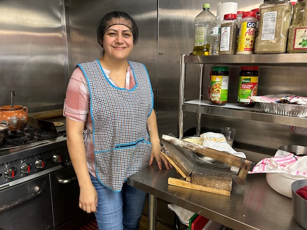 Veronica Martinez, owner of Cocina de la Tia, poses with her 24-year-old tortilla press.