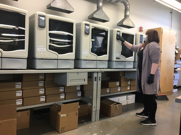 Sabrina Seaman, digital fabrication lab tech in KSU's College of Architecture and Construction Management, prepares a row of 3D printers inside KSU’s Digital Fabrication Lab.