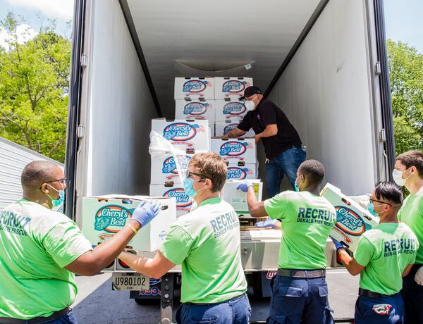 DeKalb County Fire Rescue recruits help distribute food at the giveaway.  (Jenni Girtman for Atlanta Journal Constitution)