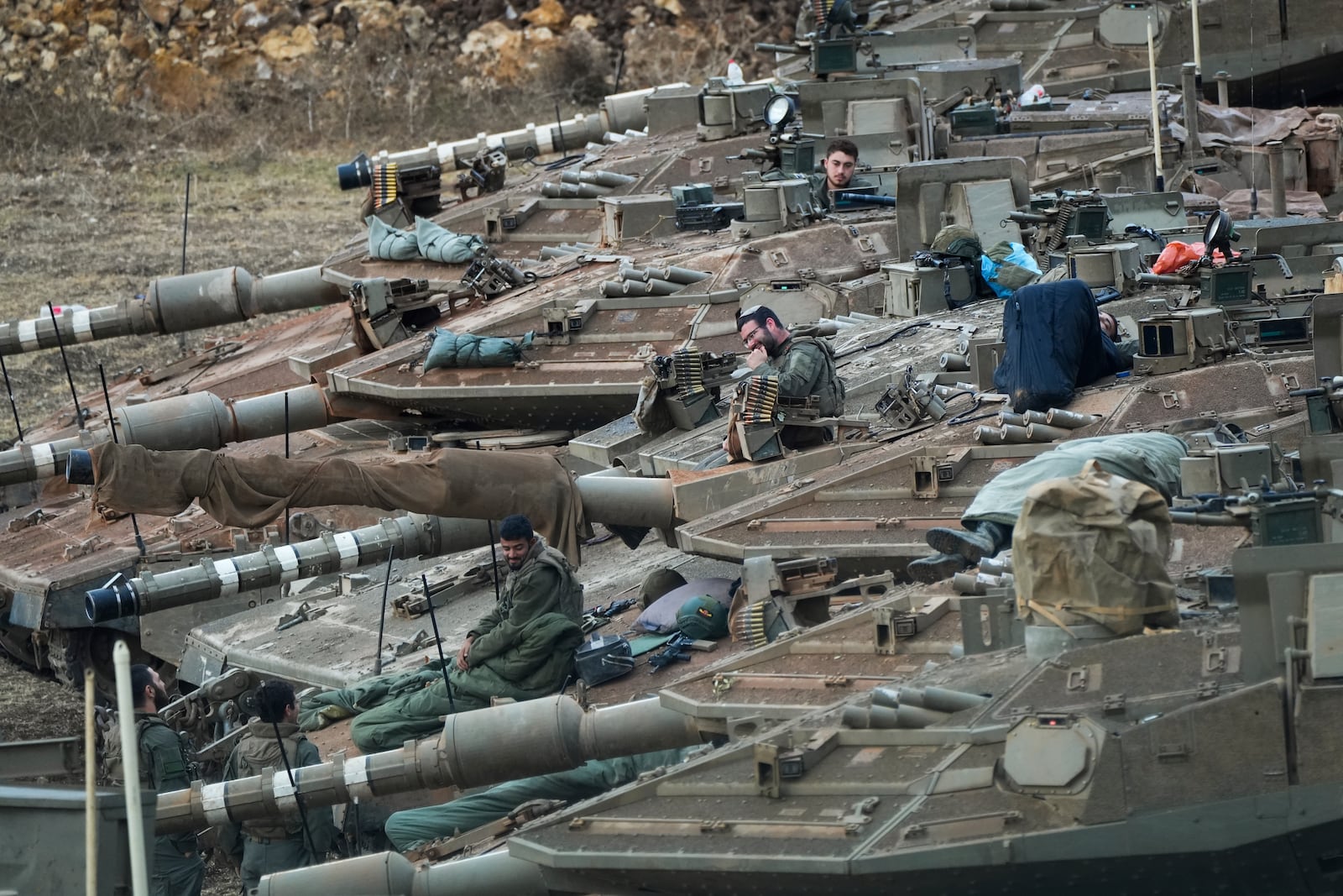 FILE - Israeli soldiers work on tanks in a staging area in northern Israel near the Israel-Lebanon border, on Oct. 1, 2024. (AP Photo/Baz Ratner, File)