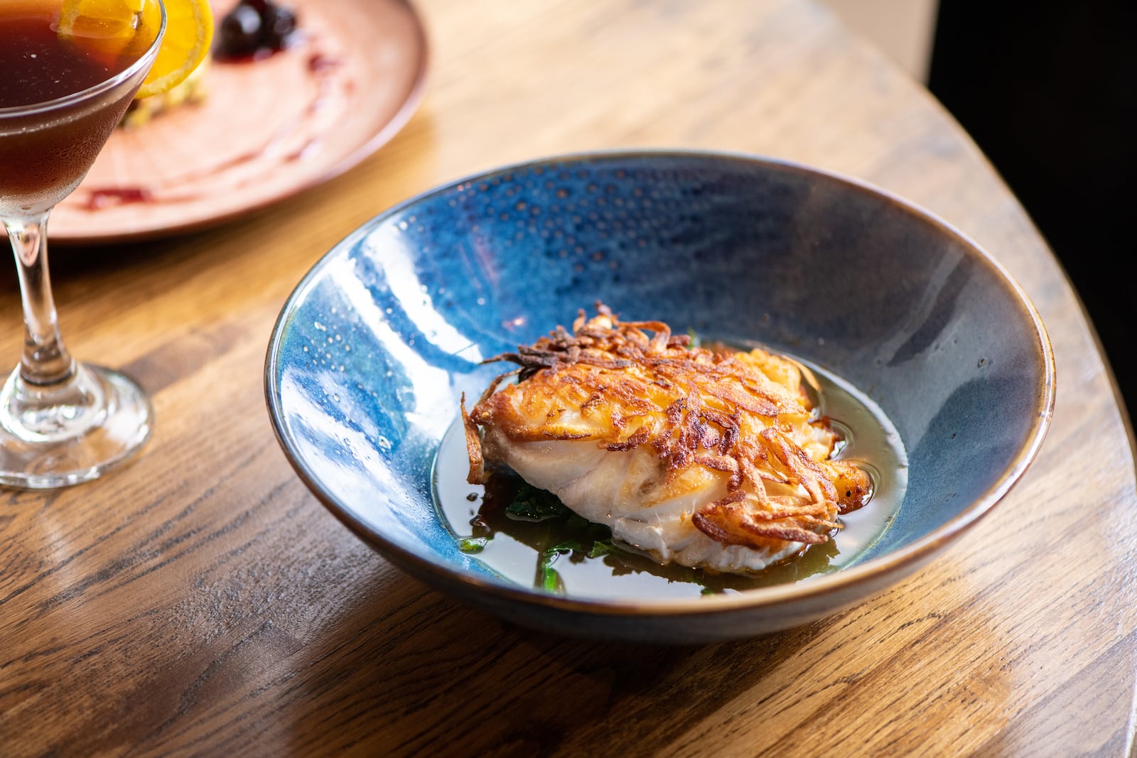 A-street Potato-Crusted Grouper with smoked paprika, garlic spinach, tomato coriander broth, and preserved lemon. (Mia Yakel for The Atlanta Journal-Constitution)