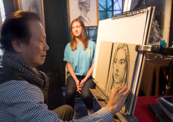 Artist Peter Ho paints Elizabeth Bennett's portrait at one of the many booths  during the 2018 Atlanta Chinese Lunar New Year Festival in Chamblee, Ga., on Sunday, Feb. 18, 2018. 