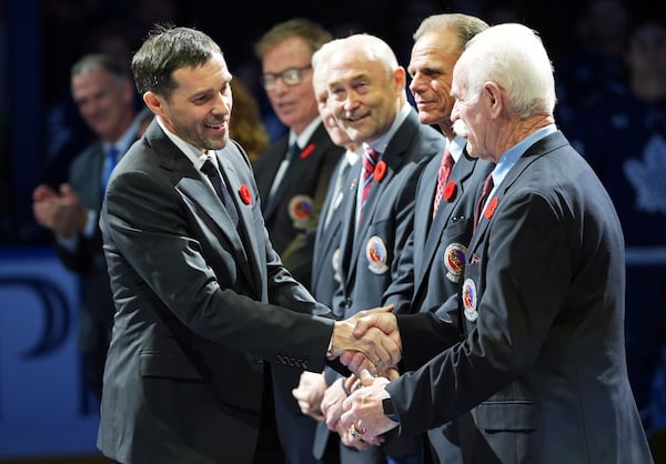 2024 Hockey Hall of Fame inductee Pavel Datsyuk, left, shakes hands with Lanny McDonald, right, during a ceremony prior to NHL hockey game action between the Detroit Red Wings and the Toronto Maple Leafs in Toronto, Friday, Nov. 8, 2024. (Frank Gunn/The Canadian Press via AP)