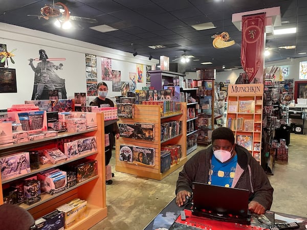 Tony Cade, owner of Challenges Games & Comics in North DeKalb Mall, has a solid following but wonders if he can afford a drastically higher rent in the proposed new development. Associate Khayman Bliss in background. Photo by Bill Torpy