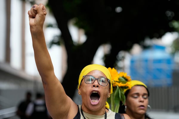 A woman shouts demanding justice before the start of the trial of councilwoman Marielle Franco’s suspected murderers, outside the Court of Justice, in Rio de Janeiro, Brazil, Wednesday, Oct. 30, 2024. (AP Photo/Silvia Izquierdo)