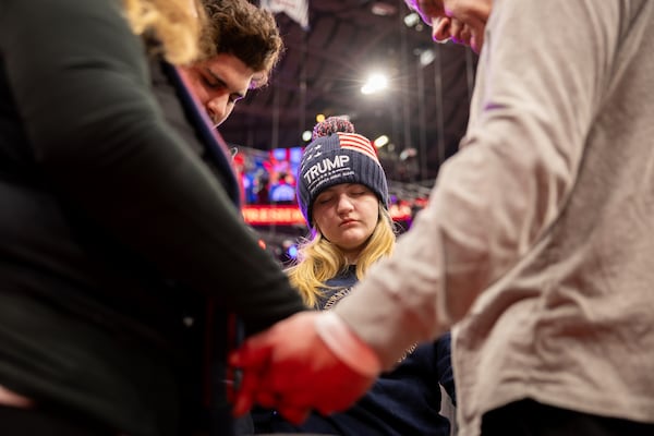 Donald Trump supporters pray as Trump’s inauguration is played on a livestream at Capital One Arena in Washington, D.C. on Monday, January 20, 2025. (Arvin Temkar / AJC)