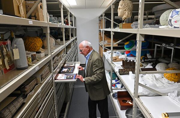 Michael Rose, executive vice president for collections and exhibitions at the Atlanta History Center, shows items from the 1996 Atlanta Olympic and Paralympic games housed at a storage facility at the museum on Tuesday, July 20, 2021. The history center has an ongoing exhibit about the 1996 Olympic Games in Atlanta. (Hyosub Shin / Hyosub.Shin@ajc.com)