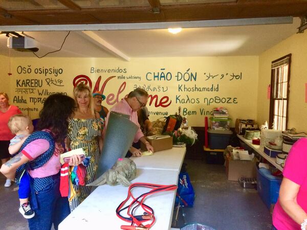 Randall Hudson, center background, tallies up the merchandise as estate sale shoppers head out to pay. Photo by Bill Torpy